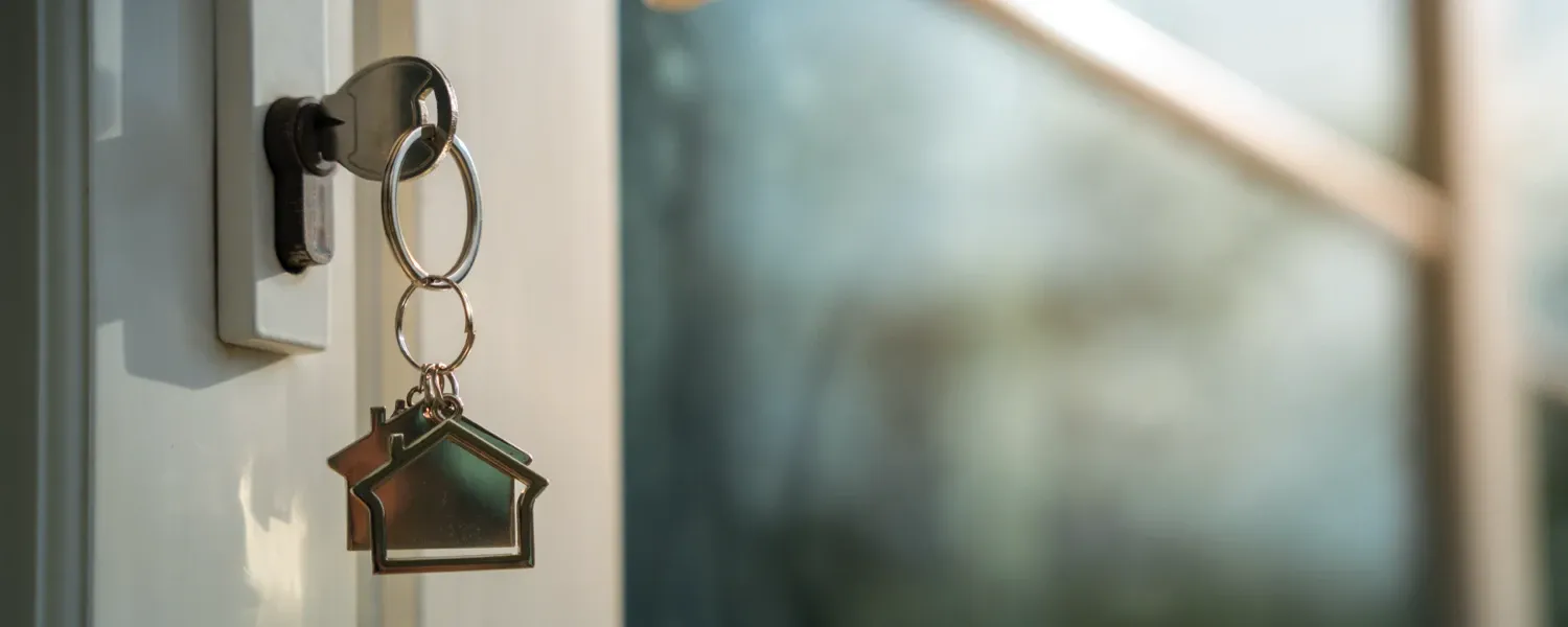 Close up of a pair of house keys in the front door of a home